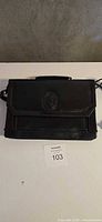 Front view of black leather YSL purse showing monogram and overall condition