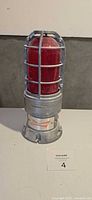 Front view of Budweiser Red Light goal lamp showing red lens, metal cage and logo on base