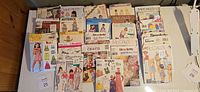 Top view of entire assortment of sewing pattern envelopes spread on table