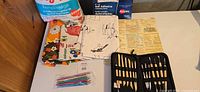 Overall lot view showing stuffing bag, laminating sheets, fabrics, sculpting tools, crochet hooks