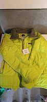 Front view of lime-green Patagonia quilted jacket laid flat