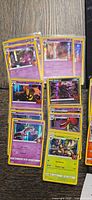 Stacks of sleeved holo cards showing Gengar, Gourgeist, Mewtwo, Trevenant