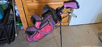 Full view of pink and purple Wilson junior stand bag with clubs