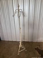 Full view of coat rack showing height, color and tripod base