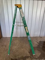 Assembled view of damaged green fiberglass rails standing in A-frame shape