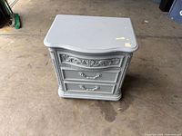 Front and top view of gray painted two-drawer cabinet showing overall form and wear