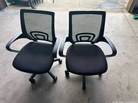 Front view of two black mesh-back chairs showing seats, armrests, bases
