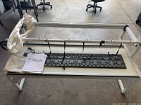 Full view of quilting frame with rails, carriage and manual on top