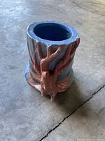 Oblique view showing sculpted tree relief, blue glaze, and terracotta clay