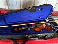 Open case showing violin, bow, interior padding