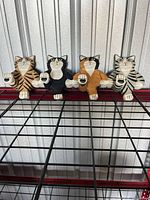 Front view of rack showing four carved cat figures and pegs