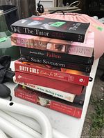 Stack of seven paperback books showing spines and titles