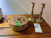 Overview of container and both candlesticks on wooden surface