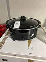 Front view of black Crock-Pot slow cooker showing glass lid, handles and power cord