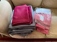 Stack of grey panels, fuchsia satin panel, sealed and loose pink panels