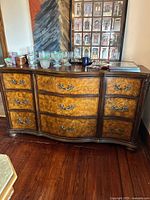 Front view showing serpentine shape, veneer pattern, metal pulls, and overall condition