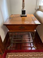 Overall view of side table next to sofa showing wood top and metal base
