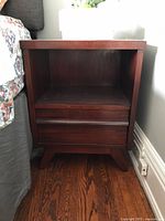 Front view of first Gibbard side table next to bed