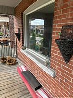 Wall-mounted woven rubber sconce planters and metal & glass lanterns beside window