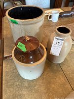 Three stoneware pieces grouped: open crock, covered crock, jug vase