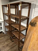 Front view of full height wooden shelving unit with six slatted shelves