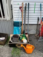 Overall lot with long-handled tools, planters, watering can
