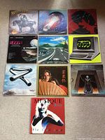 All ten album covers arranged on floor for overview