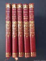Spine view of all five red gilt-decorated books