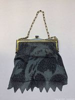 Full view of purse showing metal mesh body, gold-tone frame, chain handle