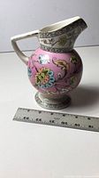 Left side view of Old Hall Indiana pattern pink pitcher with ruler showing height