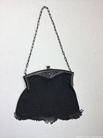 Full view of metal mesh purse hanging from chain handle