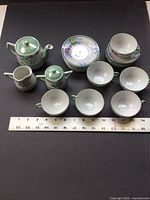Full tea set laid out with ruler for scale