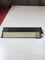 Full view of slide rule partly in case