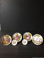 Group of five Limoges plates, three larger and two smaller, fronts visible