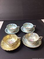 All four Paragon commemorative cup and saucer sets displayed