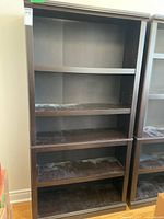 Full frontal view of tall dark brown bookcase showing five shelves
