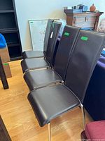 Four vinyl chrome dining chairs in a row