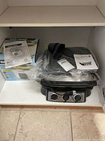 Overview showing boxed Black & Decker RC3406 rice cooker and covered President's Choice appliance with manuals