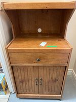 Full view of pine veneer kitchen stand showing open shelf, drawer, and cabinet