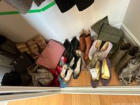 Overall view of shoes and handbags arranged on closet floor