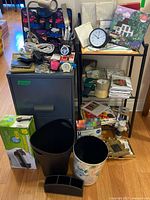 Overall view showing filing cabinet, shelf, wastebaskets, desk accessories