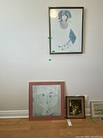 All three framed prints displayed: Rosamond portrait on wall, abstract face and interior scene leaning below