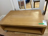 Overall view of rectangular wood veneer low table on casters