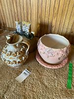 Group shot of jug, owl pot with lid, pink planter on saucer