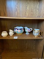 Shelf view of five ceramic pieces