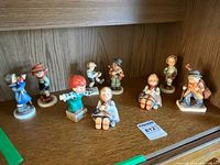 Shelf view showing all nine ceramic children figurines