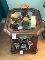 Top view of wooden end table showing octagonal glass insert and overall condition; decorative items not included