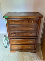 Front view showing entire chest, drawers, carving and hardware