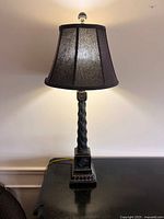 Full view of lamp lit, showing shade, base, finial, cord