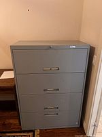 Front view of gray 4-drawer metal filing cabinet